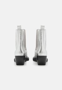 Botas metálicas plateadas hasta el tobillo con tacón bloque, que cuentan con paneles elásticos en los laterales, textura suave y tiradores en la parte trasera para un fácil uso.