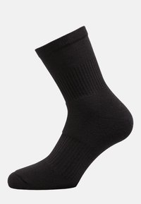 Calcetín negro hasta el tobillo con diseño acanalado y textura suave, de color sólido y con refuerzo en el talón para mayor durabilidad.