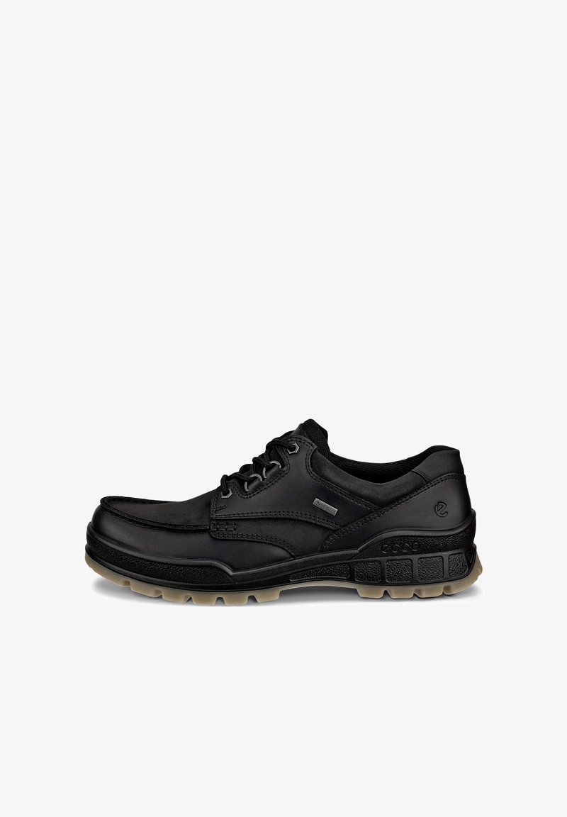 Chaussure décontractée noire en cuir basse avec fermeture à lacets et semelle en caoutchouc beige texturée, montrée de profil droit sur fond blanc.