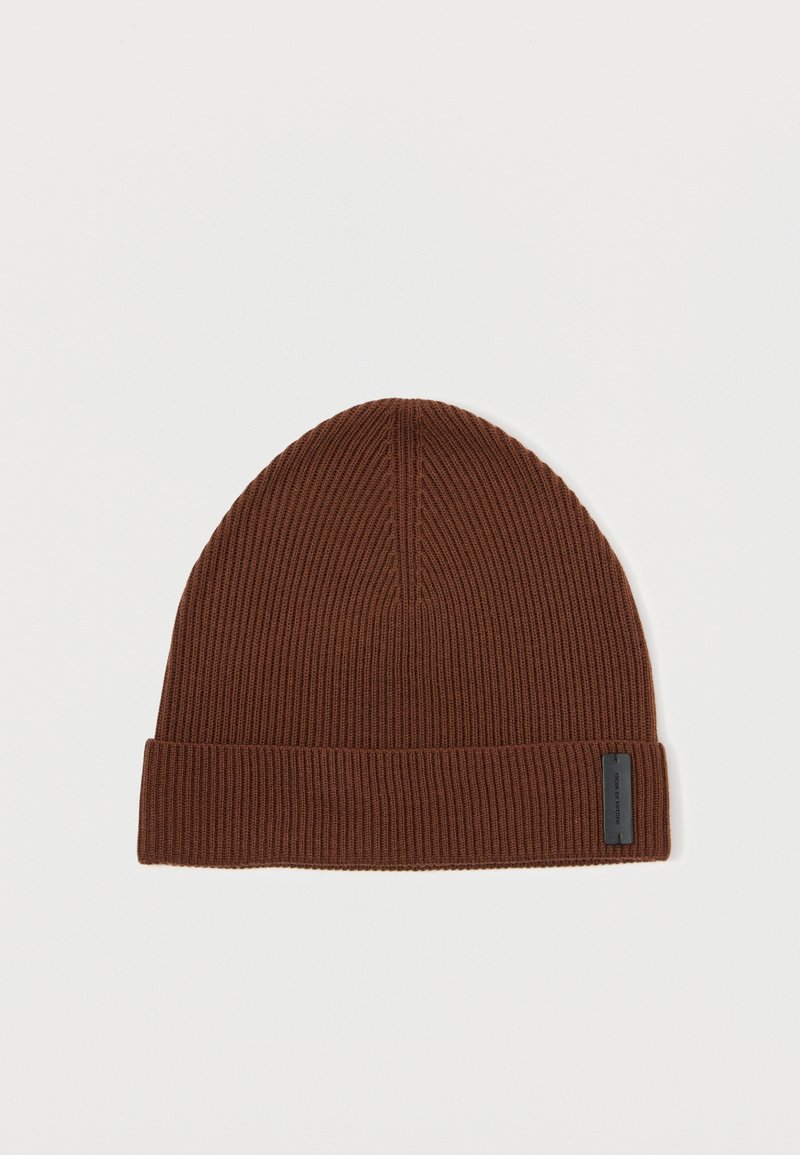 Gorro de punto marrón con textura acanalada, que presenta un puño doblado y una pequeña etiqueta negra. La parte superior es redondeada y suave.