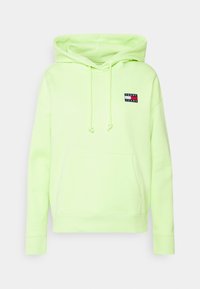 Felpa verde lime con tasca a marsupio frontale, cappuccio con lacci e una piccola patch logo nera, rossa e bianca sul petto.