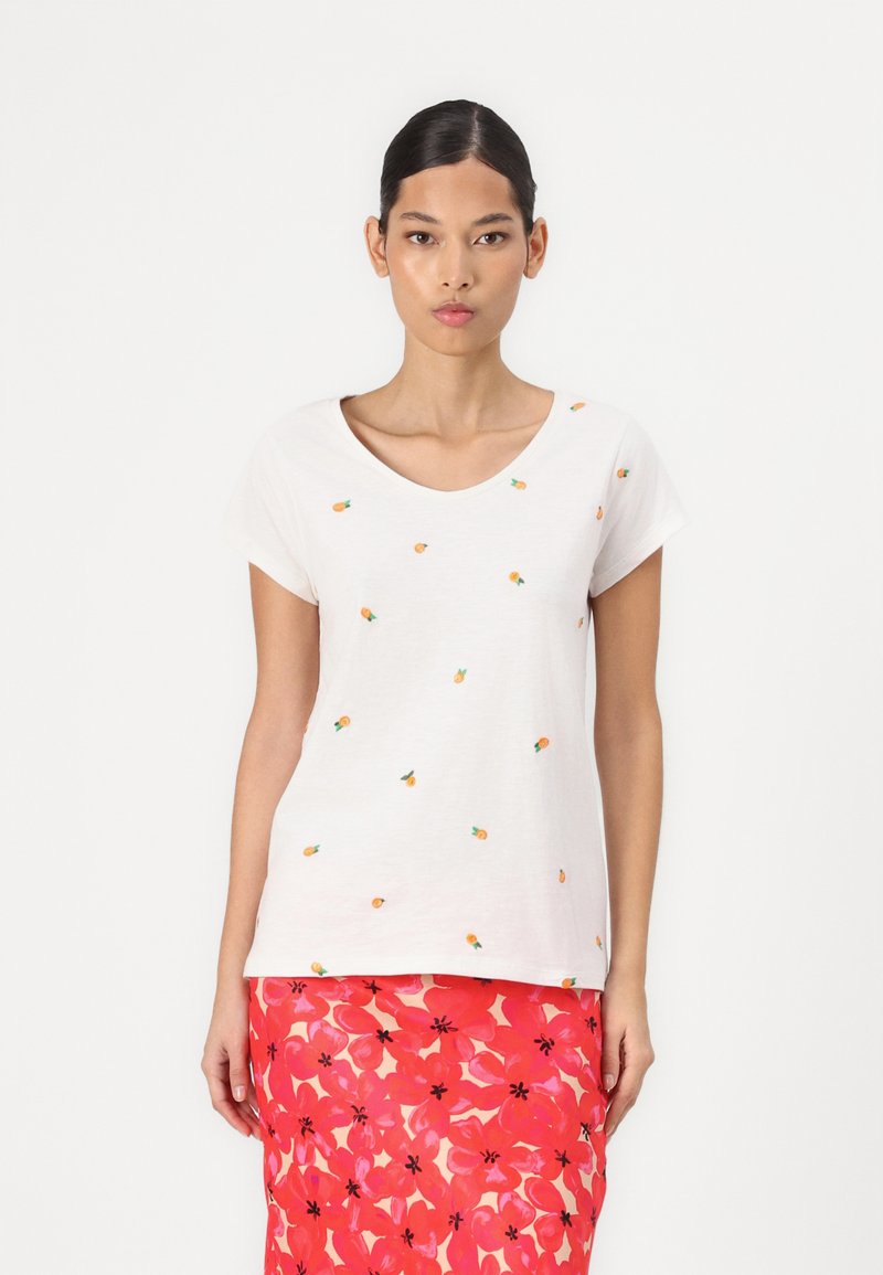 White short-sleeved T-shirt made of soft fabric, featuring small embroidered pineapples in orange and green, with a scoop neckline.