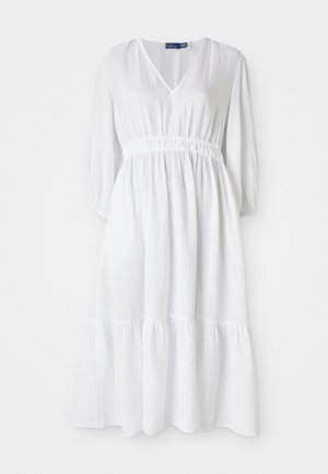Robe blanche avec un décolleté en V, taille élastique et manches trois-quarts. Elle présente un ourlet à volants en couches et un tissu texturé.