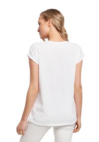 Weißes Baumwoll-T-Shirt mit umgeschlagenen kurzen Ärmeln, rundem Halsauschnitt und lockerer Passform, von hinten gesehen, mit einer glatten Textur.