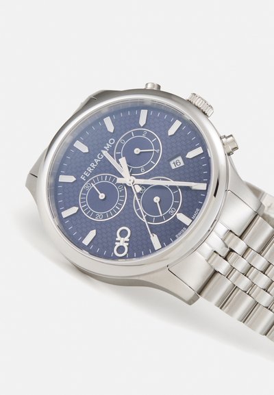 Silver stainless steel watch with a textured dark blue dial, three subdials, date display, and a metal link bracelet.