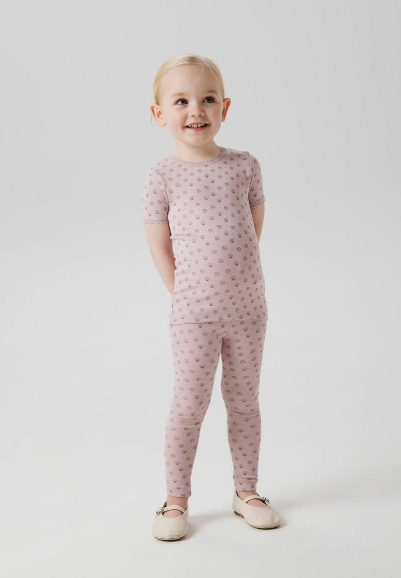 Zestaw piżamowy w jasnoróżowym materiale z fioletowymi kropkami. Krótki rękaw i dopasowane legginsy. Miękka faktura i prosty design.