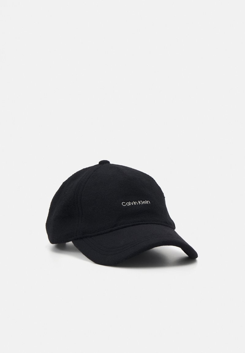 Casquette de baseball noire Calvin Klein avec visière courbée sur fond blanc, présentant un petit logo de marque brodé en blanc au centre devant.