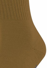 Calzino marrone con un bordo a coste, che mostra texture e forma. La zona delle dita è curvata, con un piccolo dettaglio blu vicino al bordo.