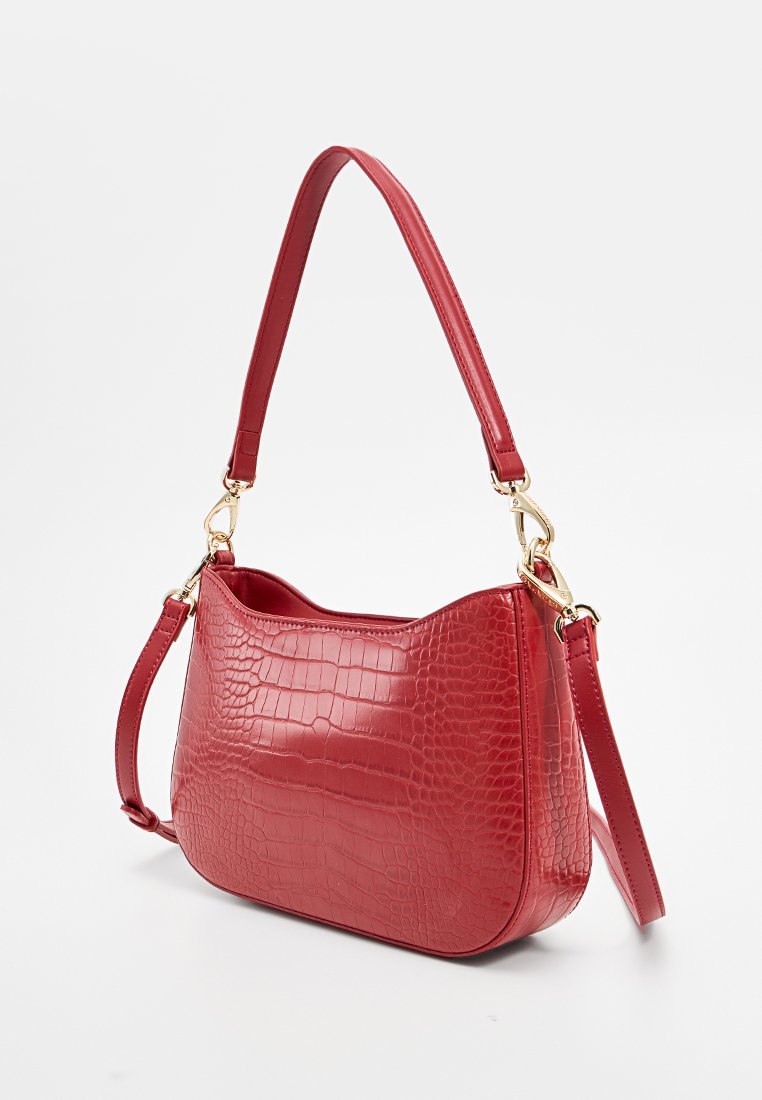 Borsa a tracolla in ecopelle rossa con texture a coccodrillo, caratterizzata da una forma curva, hardware tono oro e una tracolla staccabile.