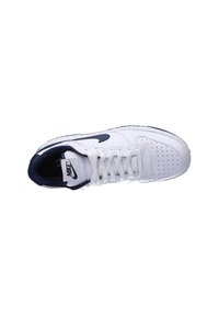Chaussure de sport blanche avec tige en cuir perforé, accents bleu marine et semelle en caoutchouc blanche. Présente des lacets et un logo signature sur la languette.