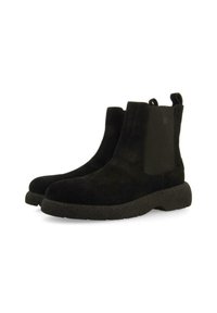 Botas de tobillo de ante negro con paneles laterales elásticos, punta redonda y suela de goma texturizada. Cuenta con tiradores para facilitar su puesta.