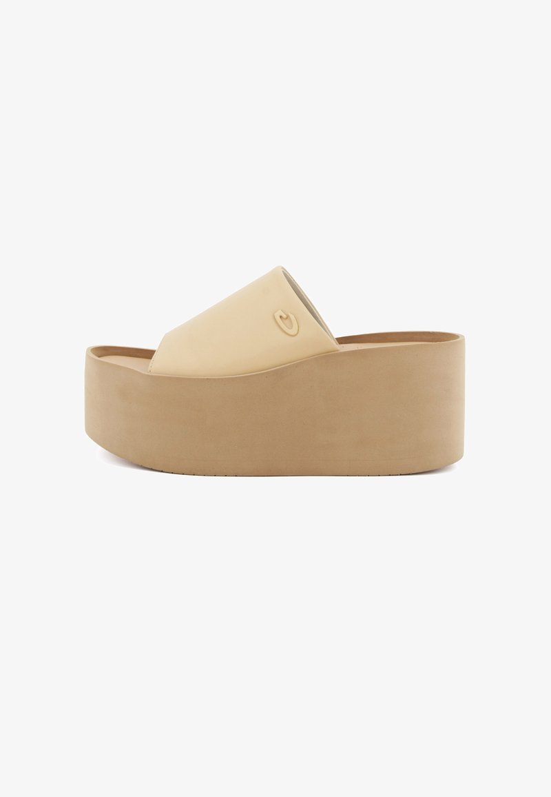 Sandali platform a infradito beige con una finitura liscia, punta aperta e design superiore curvo. Presentano un logo inciso in modo discreto sul lato.