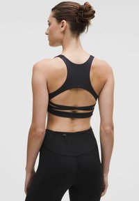 Svart sport-bra med racerback-design, som har flera horisontella remmar över ryggen för ökad stöd och andningsförmåga.
