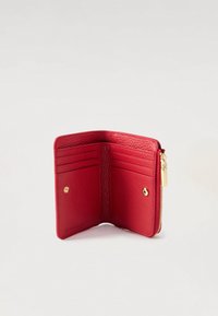 Červená texturovaná kožená peněženka otevřená, aby ukázala šest slotů na karty a dva oddíly na stiskací tlačítko, se zlatým zipem na straně.