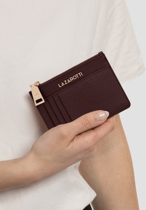 Porte-cartes en cuir bordeaux avec finition texturée, quincaillerie dorée, et logo embossé ; doté de plusieurs fentes pour cartes et d'une poche zippée.
