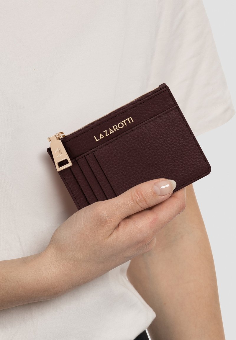Portafoglio in pelle bordeaux con finitura testurizzata, hardware dorato e logo impressa; presenta più scomparti per carte e una tasca con zip.
