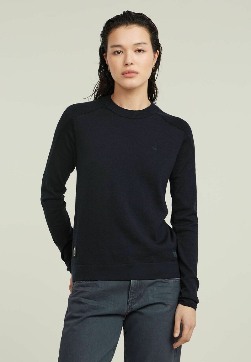 Maglione girocollo navy, in morbido materiale a maglia, collo giro, polsini a costine, logo discreto sul petto, silhouette aderente, design classico.