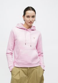 Ροζ ανοιχτόχρωμο φούτερ με κουκούλα σε βαμβακερό μείγμα, που διαθέτει μπροστινή τσέπη και κορδόνια με μεταλλικές άκρες, συνοδευόμενο από μικρή λεπτομέρεια με λογότυπο.