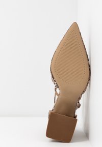 Chaussure à talon haut avec une pointe effilée, présentant un dessus en imprimé animal texturé et une semelle en caoutchouc lisse, brun clair, avec un motif strié.