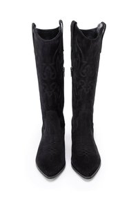 Zwarte suède kniehoge laarzen met spitse tenen en decoratieve stikpatronen, gezien van voren op een witte achtergrond.