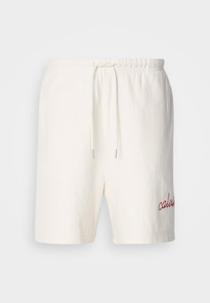 Shorts bianchi in cotone con vita elasticizzata e cordino. Presentano la scritta "calvin" ricamata in rosso sulla gamba sinistra. Tessuto morbido, design semplice.