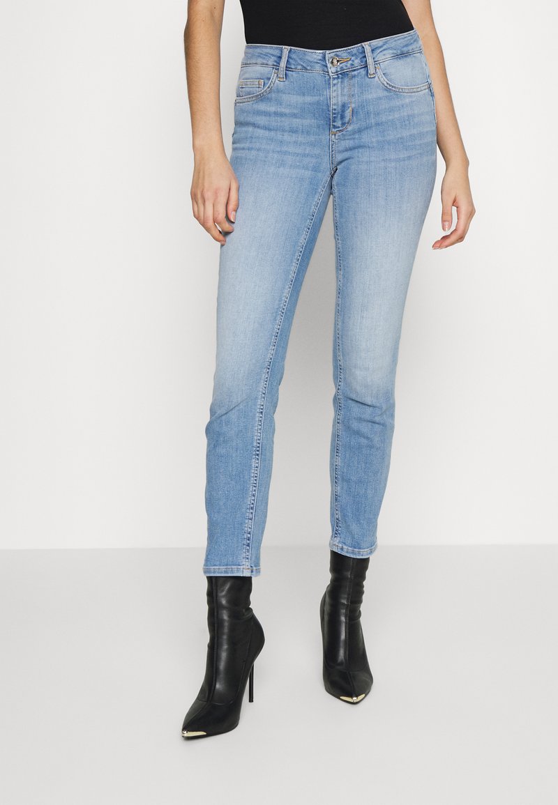 Hellblaue Skinny-Jeans aus Denim-Material mit mittlerer Hüfthöhe, versehen mit dezenten Ausbleichungen und einem klassischen Fünf-Taschen-Design.