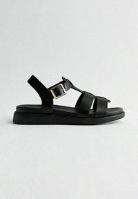 Svarta sandaler med platt sula, med breda remmar och spänne. Tillverkade av ett slätt material med en minimalistisk design.