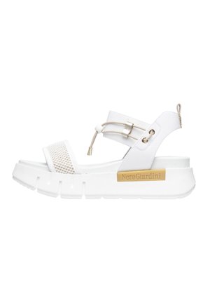 Witte platform sandalen met mesh accenten, verstelbare band en gouden hardwaredetail. Voorzien van een chunky zool met een textuurfinish.