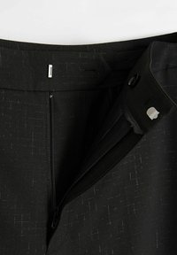 Czarne spodnie z delikatnym wzorem, z zamkiem błyskawicznym i zapięciem na guzik oraz gładką talią. Brak widocznych kieszeni.