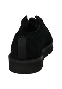 Scarpa in suede nera con punta tonda, suola in gomma bassa e dettagli in tessuto testurizzato. Presenta un dettaglio a righe verticali sul tallone.