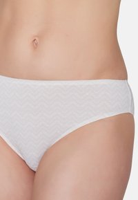White bikini bottom with a textured zigzag pattern and subtle logo detail. Made from smooth fabric, mid-rise design, and minimal coverage.