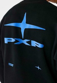 Sudadera negra con gran texto azul "PXP" y diseños de estrellas en la parte posterior. El material parece suave, con cuello redondo y puños acanalados.