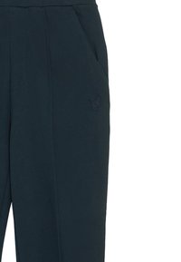 Marineblaue Jogginghosen aus weichem Material, mit Seitentaschen und einem kleinen eingeprägten Logo am linken Oberschenkel. Elastischer Bund für zusätzlichen Komfort.