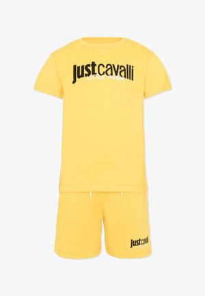 Geel t-shirt met korte mouwen en korte broek set met zwarte "Just Cavalli Little Rogue" logo tekst op de borst en linkerpijp.