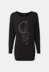 Maglione lungo nero a maniche lunghe con un grande logo "GUESS" in borchie argentate. Realizzato in tessuto morbido con un colletto rotondo e polsini a costine.