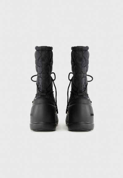 Czarne wodoodporne buty z pikowanym cholewką, okrągłym noskiem, regulowanym sznurowaniem oraz grubą gumową podeszwą zapewniającą przyczepność i wsparcie.