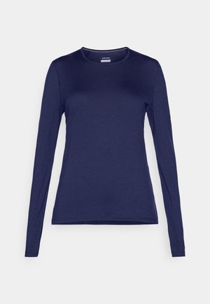 Camicia a maniche lunghe realizzata in tessuto blu navy con scollatura rotonda e design aderente. Presenta cuciture semplici lungo i bordi.