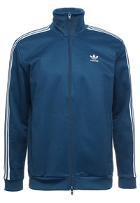 Námořnická modrá zateplená bunda Adidas na zip vyrobená z měkké tkaniny, s vysokým límcem, bílými třemi pruhy a malým logem na hrudi.