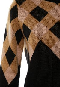 Pull en tricot avec un grand motif losange en noir, beige et rose clair couvrant la manche et le haut du torse.