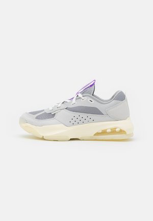 Scarpa sportiva grigia con tomaia in rete e materiale sintetico, dettagli perforati, lacci bianchi e intersuola crema con ammortizzazione ad aria visibile.