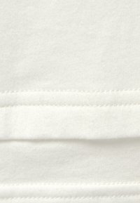 White cotton fabric with a smooth texture, featuring a simple design and evenly spaced stitching along the hem and seams.