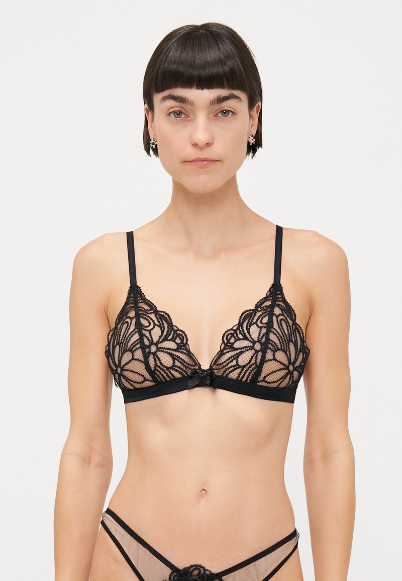 Bralette triangulaire en dentelle noire avec motif floral, bonnets transparents et bretelles réglables. Présente un petit nœud central et un détail de bande.