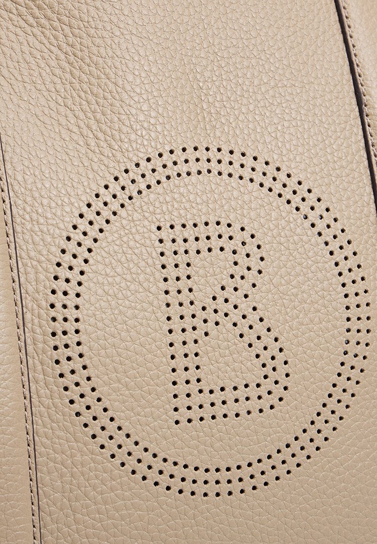 Beige leren handtas van gestructureerd leer met een geperforeerd circulair logo met de letter "B" in het midden en contrasterende stiksels langs de randen.