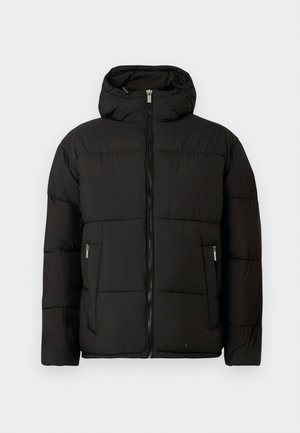 Mustakarva puffer-jakk, millel on kapuuts, ees tõmblukk ja lukuga küljetaskud, esitatud helesinisel taustal.