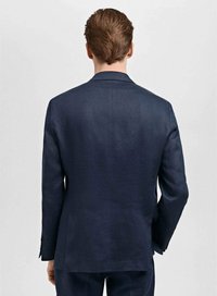 Blazer tailleur bleu marine avec une silhouette structurée, deux boutons, revers crantés et texture de tissu lisse. Comprend des fentes latérales et des manches longues.