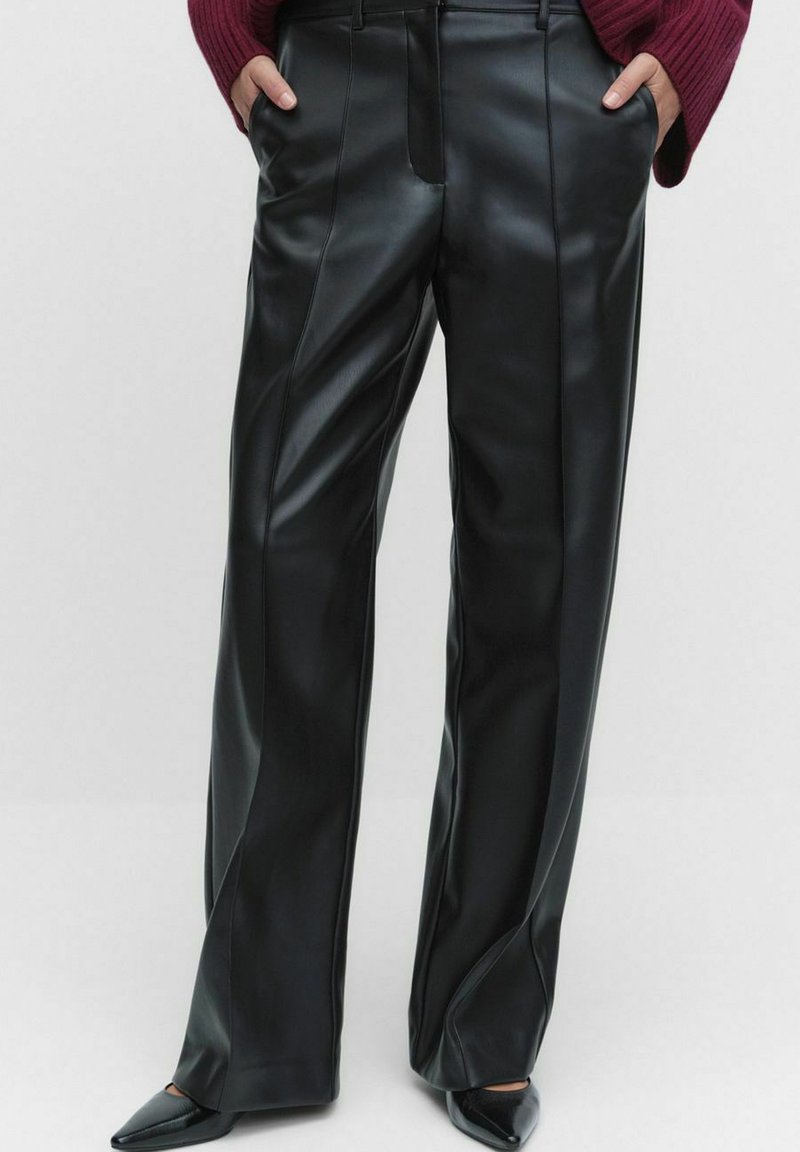 Musta keinonahasta valmistetut leveät housut, joissa on sileä pinta ja etusaumat. Ominaisuuksiin kuuluu korkea vyötärö ja sivutaskut.