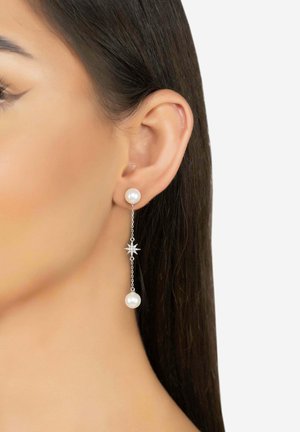 Silver earrings with a pearl at the top and a dangling pearl below, connected by a thin chain featuring a star accent in the center.