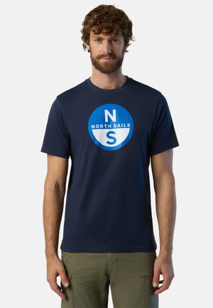 Camiseta de algodón azul marino con cuello redondo, que presenta un gráfico circular en blanco y azul con "NORTH SAILS" y el logotipo en el centro.