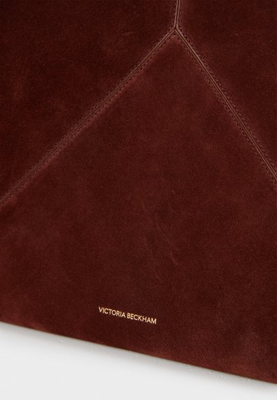 Μπορντό σουέντ τσάντα με γεωμετρικό σχέδιο, διαθέτει ορατές ραφές. Χρυσό σήμα "Victoria Beckham" ανάγλυφο στο κάτω μέρος.
