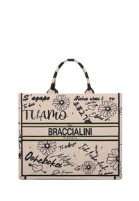 Borsa a tracolla in tela con sfondo beige, motivi floreali neri, testo scritto a mano e un logo. Presenta doppi manici neri e una forma strutturata.